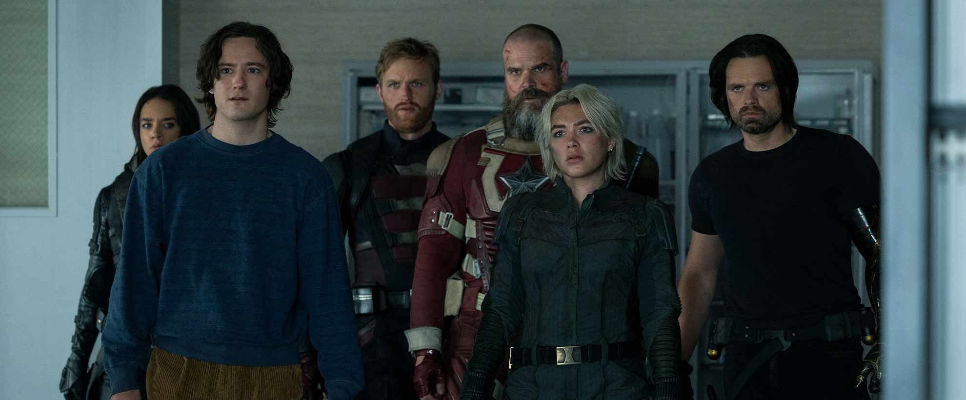 The cast of the Thunderbolts stand in a row, in a science lab